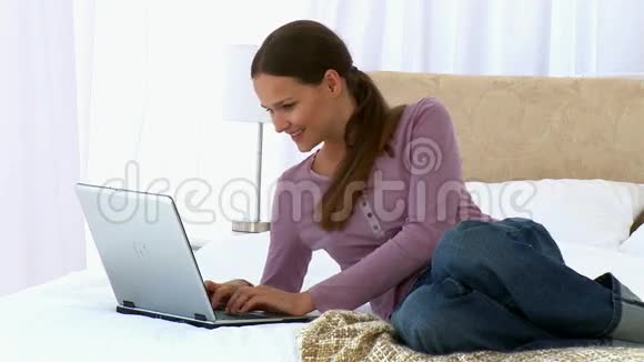 漂亮的女人看着笔记本电脑视频的预览图