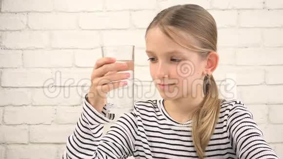 孩子在厨房里喝水口渴的十几岁女孩在学习一杯淡水孩子的医疗保健视频的预览图