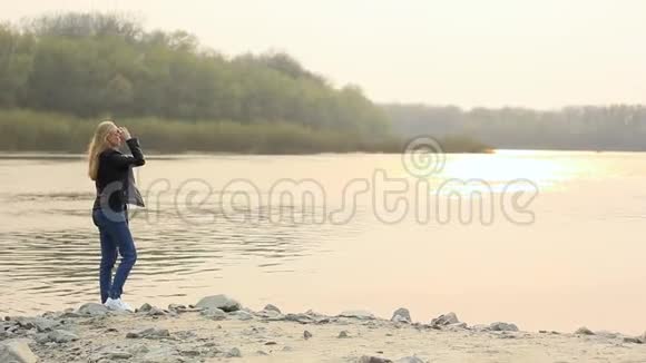 日落时河岸上的女孩视频的预览图