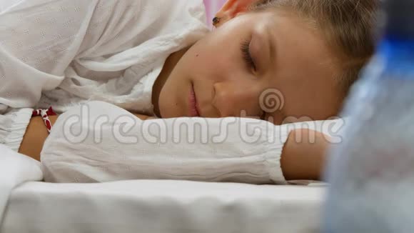 生病的孩子睡在床上生病的孩子住院吃药的小女孩视频的预览图