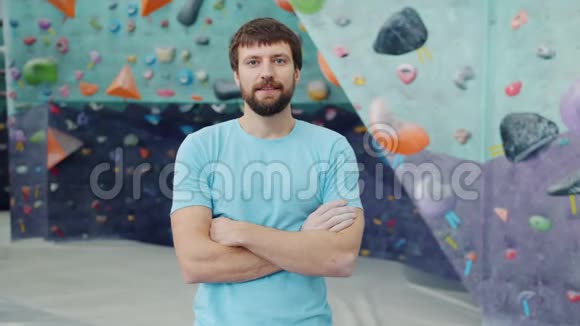 英俊的年轻运动员站在室内攀岩设施的肖像视频的预览图