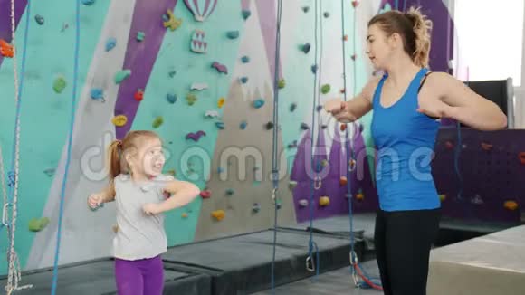 在室内健身房爬墙前母亲和女儿热身运动缓慢视频的预览图