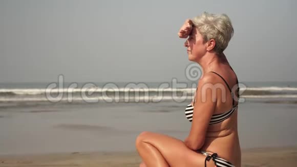一个身材好的成熟女人坐在沙滩上冲浪视频的预览图