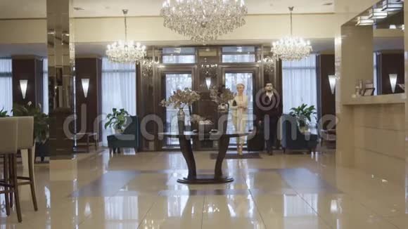 高加索人带着旅行袋进入豪华酒店前厅并接近视频的预览图