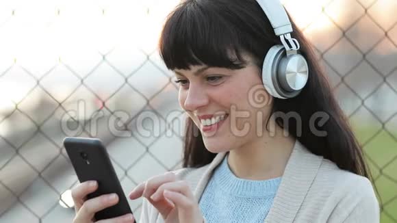 快乐的成年女人在街上听音乐视频的预览图