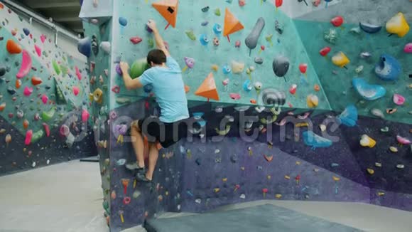 运动男训练室内攀岩运动上墙拿人造石头视频的预览图