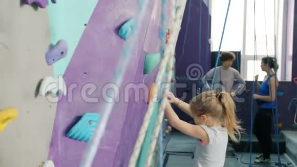 小女孩在攀岩运动中爬人造墙享受极限活动视频的预览图