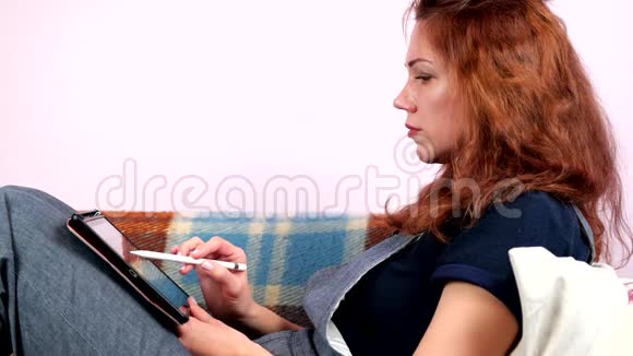 一名年轻女子在隔离期间在家中的平板电脑工作社会距离视频的预览图