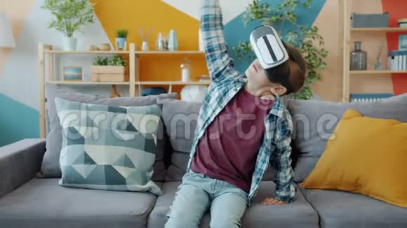 快乐的孩子玩增强现实眼镜在家戴耳机打手势视频的预览图