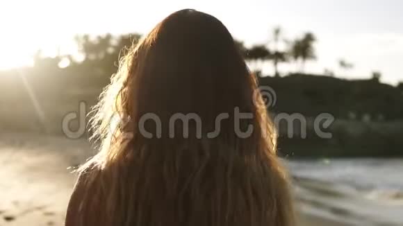 嬉戏的年轻女子在夏日海滩享受暑假一位头发蓬乱的女人正在海滩上散步视频的预览图