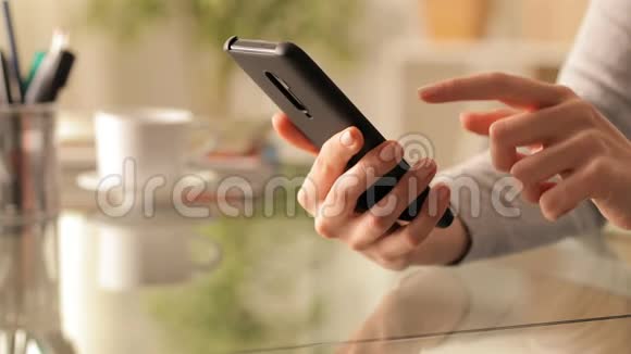 女人在桌子上用智能手机视频的预览图