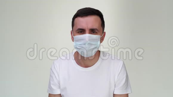 生病的欧洲年轻人戴着医疗面具在镜头前咳嗽着拳头视频的预览图