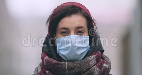年轻女子戴着防护面具独自站在城市里视频的预览图