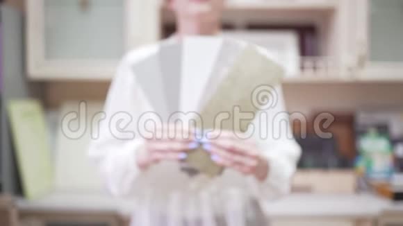 一位女卖家在相机中展示了家具选择的例子经理手中的样品视频的预览图