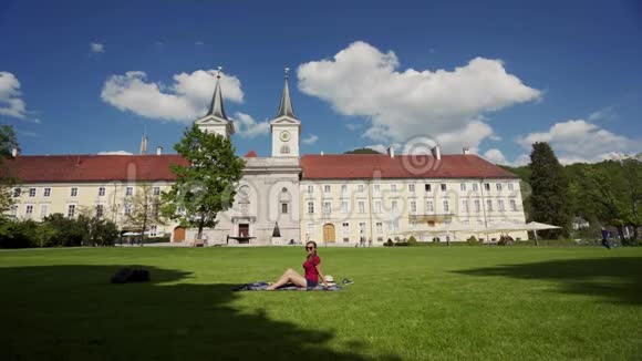 戴墨镜的女人在巴伐利亚的特格尔尼西堡的绿色草坪上野餐视频的预览图