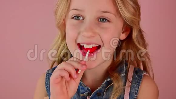 特写迷人的天使美丽的女孩舔红色糖果慢动作视频的预览图