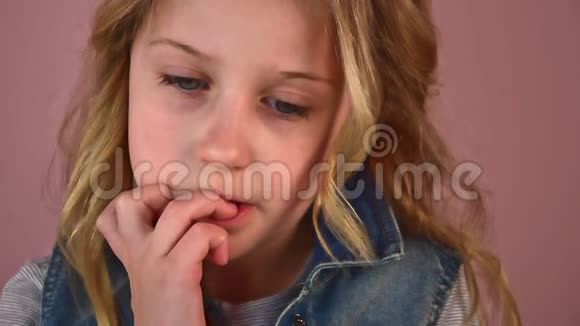 忧郁的金发白种人小女孩紧张地咬着指甲视频的预览图