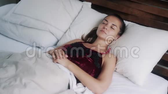 年轻女子睡觉睁开眼睛醒来躺在床上微笑视频的预览图