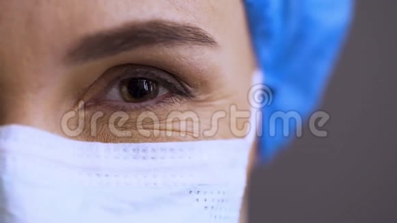 特写惊讶女医生的脸震惊的Covid19外科医生戴着面具点头一只雌性的大射视频的预览图