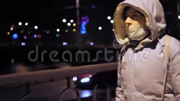 晚上街上戴防护面具的女孩的肖像视频的预览图