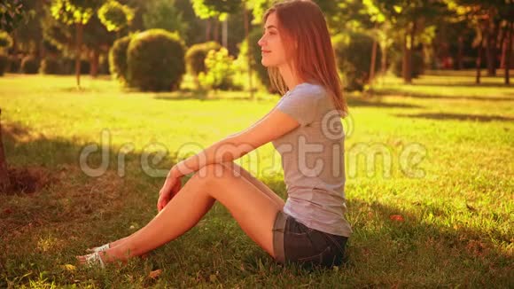 快乐的女性坐在草坪上视频的预览图