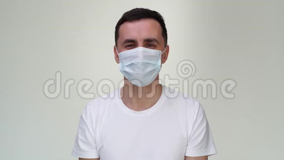 戴着医用面具的严肃青年用两只交叉的手表示停止姿势视频的预览图