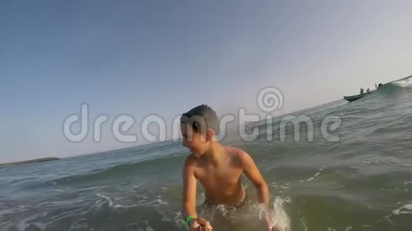微笑的男孩在海水中奔跑和游泳视频的预览图