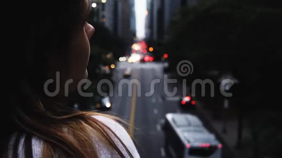 在美国纽约一位年轻的黑发女性站在桥上看着交通道路视频的预览图