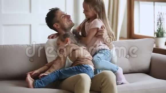 快乐的父亲和可爱的小女孩在沙发上放松视频的预览图