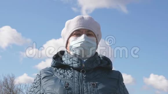 户外的老年妇女戴着医用口罩在街上戴着防护面具的大流行病妇女健康和安全概念视频的预览图