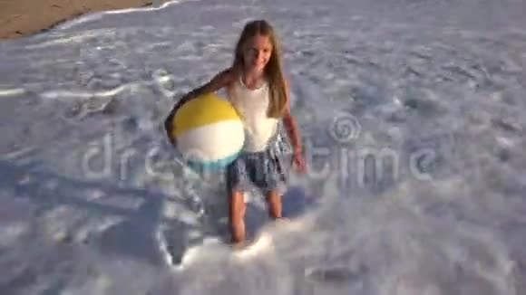孩子在日落时在海滩上玩耍快乐的孩子在海浪中行走金发女孩在海边视频的预览图