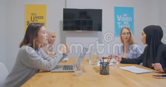 办公室里的四项不同的工作色彩鲜艳的报纸商业女孩的图表同事的讨论争论女人的头巾视频的预览图