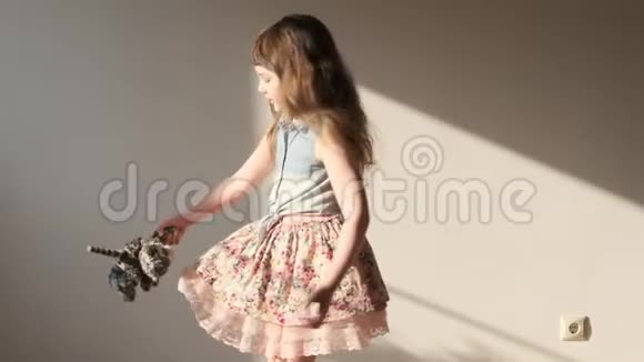 女孩和她最喜欢的玩具在阳光房旋转视频的预览图