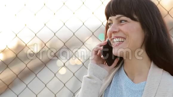 快乐的成年女人在街上打电话视频的预览图