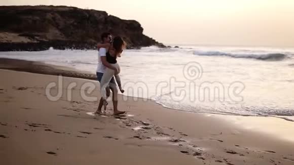 恋爱中的情侣穿着衬衫的男人在海滩上转过他可爱的女人在感官上亲吻全方位观赏欢乐视频的预览图