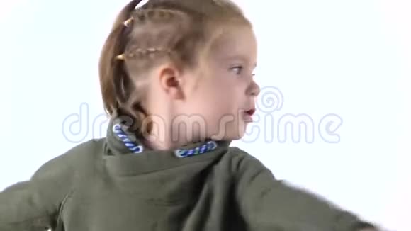 扎着辫子的小女孩在白色背景上嬉戏和旋转孩子的情感慢动作关门视频的预览图