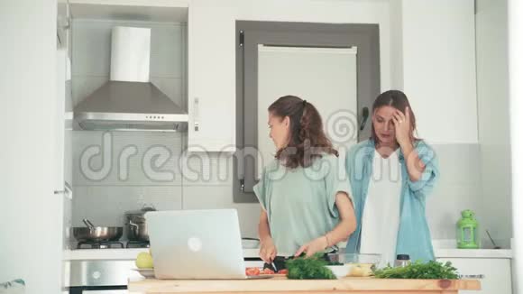 两个年轻漂亮的女人在明亮的厨房做饭视频的预览图