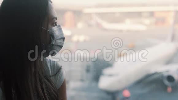 侧视图戴防护面罩的女性肖像机场窗口COVID19视频的预览图