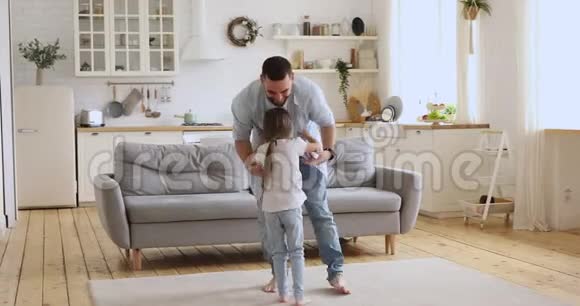 快乐的父亲和可爱的女儿在厨房跳舞视频的预览图