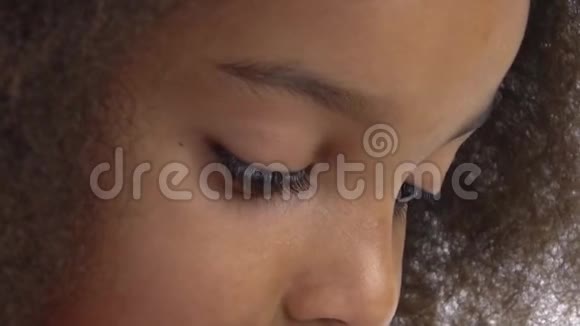 非洲裔美国卷毛女孩俯视白色背景用长长的黑色睫毛闭上棕色的眼睛慢动作视频的预览图