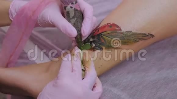 一个职业女性纹身师在一个年轻女孩的腿上纹身视频的预览图
