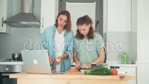 两个年轻的高加索女人在做饭的时候通过网络和朋友聊天视频的预览图