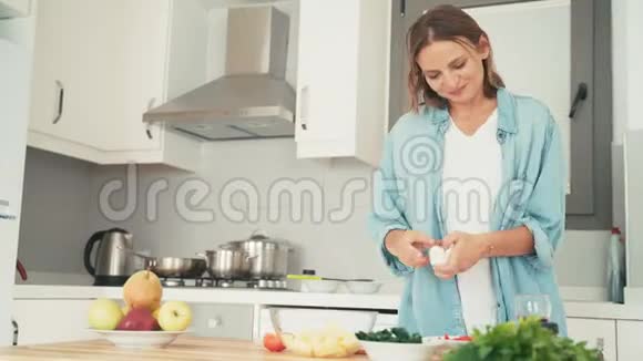 年轻的白种人快乐的女人在厨房做饭时玩得很开心视频的预览图
