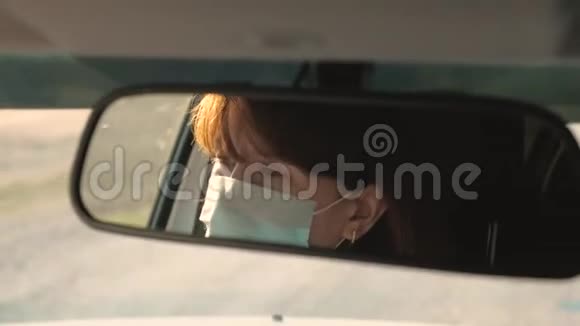 自由女孩在汽车里戴着面具旅行防止病毒和细菌女孩开车健康的年轻女性视频的预览图