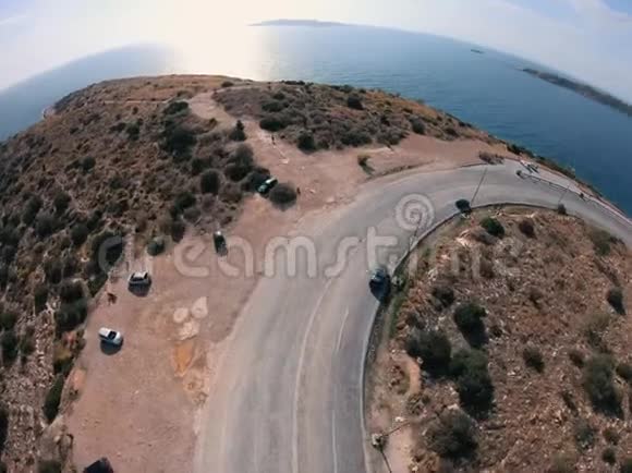 一架无人机在海滨转弯的道路视频的预览图
