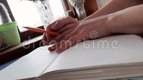 手拿铅笔在笔记本上视频的预览图