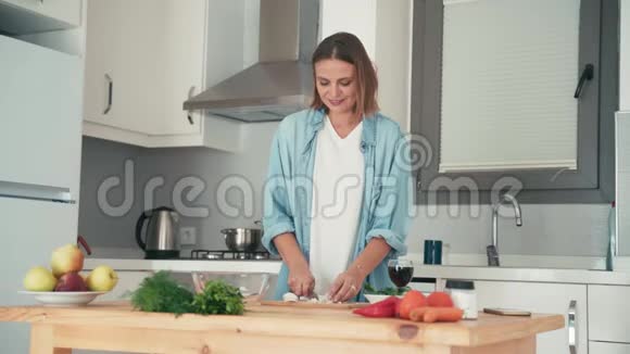 年轻漂亮的白种人女人在她明亮的厨房里做饭视频的预览图