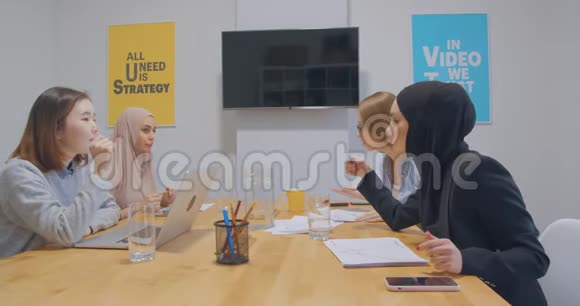 办公室里的四种不同的工作色彩鲜艳的报纸商业女孩的图表同事的讨论女人的头巾视频的预览图