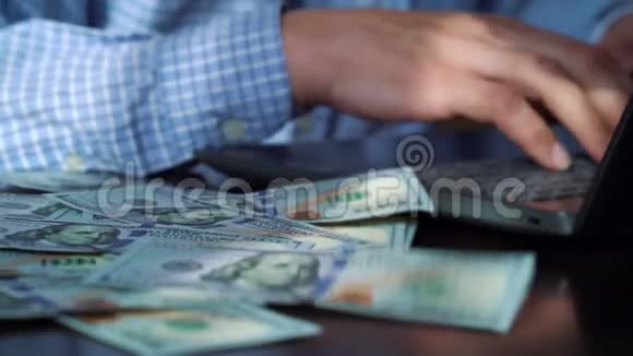 百元钞票落在手提电脑上的自由职业者桌上视频的预览图