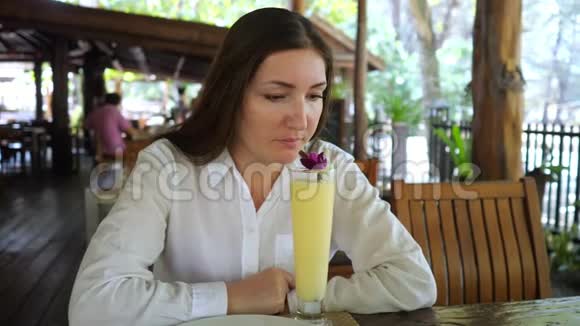 年轻女子在咖啡厅喝水果鸡尾酒视频的预览图